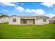 Backyard view of the home with a large grassy area and a screened in patio at 7609 Winter Shade Dr, Orlando, FL 32822