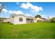 Back exterior view shows large yard, screened patio, and privacy fencing at 7609 Winter Shade Dr, Orlando, FL 32822