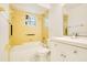 Retro bathroom featuring yellow tiles, tub, and white fixtures for a clean and classic style at 7609 Winter Shade Dr, Orlando, FL 32822