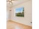 Bright bedroom features wood floor, ceiling fan, and window with security bars that fill the space with natural light at 7609 Winter Shade Dr, Orlando, FL 32822
