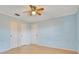 Bright bedroom features wood floor, ceiling fan, with doors that fill the space with natural light at 7609 Winter Shade Dr, Orlando, FL 32822