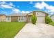 Charming single-story home with stone accents, well-maintained lawn, and a two-car garage at 7609 Winter Shade Dr, Orlando, FL 32822