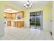 Kitchen with oak cabinets, white appliances, tile floors, and a sliding door to the outdoors at 7609 Winter Shade Dr, Orlando, FL 32822