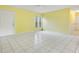 Bright living room featuring yellow walls, white tile floors, and multiple windows for natural light at 7609 Winter Shade Dr, Orlando, FL 32822