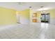 Spacious living room with white tile floors, yellow walls, and sliding glass doors to the outdoors at 7609 Winter Shade Dr, Orlando, FL 32822