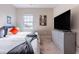 Bright and inviting bedroom featuring two twin beds and an entertainment center with a large TV at 7951 Haverhill Way, Kissimmee, FL 34747