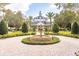 Beautiful clubhouse surrounded by lush landscaping and a circular driveway with a decorative fountain at 7951 Haverhill Way, Kissimmee, FL 34747
