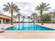 Large community pool area featuring lounge chairs and palm trees, creating a tropical and inviting ambiance at 7951 Haverhill Way, Kissimmee, FL 34747