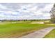 Expansive view of a well-manicured golf course with sand traps and community houses in the background at 7951 Haverhill Way, Kissimmee, FL 34747