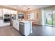 Eat-in kitchen featuring modern appliances, an island with a sink, dining area, and access to the outdoor space at 7951 Haverhill Way, Kissimmee, FL 34747