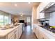 Well-lit kitchen featuring stainless steel appliances, quartz countertops, a central island, and stylish white cabinetry at 7951 Haverhill Way, Kissimmee, FL 34747