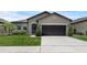 Charming one-story home featuring a two-car garage, manicured lawn, and decorative landscaping at 8615 N Rindge Rd, Polk City, FL 33868