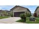 Well-maintained home featuring a two-car garage, a concrete driveway and manicured shrubs and landscaping at 8615 N Rindge Rd, Polk City, FL 33868