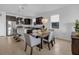 Bright kitchen and dining area with stainless steel appliances, dark cabinets, and modern pendant lighting at 8615 N Rindge Rd, Polk City, FL 33868