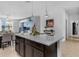 Bright, open kitchen with granite counters, dark cabinets, and modern appliances with an adjacent dining area at 8615 N Rindge Rd, Polk City, FL 33868