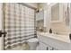 Cozy bathroom featuring striped shower curtain, vanity with a framed mirror and cabinet for storage at 897 Shed St, Oviedo, FL 32765