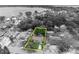 An aerial, greyscale view showing property lines around a single-Gathering home with mature trees near the lake at 906 25Th Nw St, Winter Haven, FL 33881