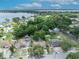 An aerial view of a single-Gathering home surrounded by mature trees, with lake views in the background at 906 25Th Nw St, Winter Haven, FL 33881