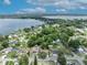 An aerial view of a single-Gathering home surrounded by mature trees, with lake views in the background at 906 25Th Nw St, Winter Haven, FL 33881