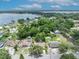 An aerial view of a single-Gathering home surrounded by mature trees, with lake views in the background at 906 25Th Nw St, Winter Haven, FL 33881