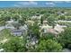 An aerial view showcases a neighborhood with mature trees and a mix of single-Gathering homes on a sunny day at 906 25Th Nw St, Winter Haven, FL 33881
