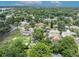 An aerial view of a neighborhood with mature trees and single-Gathering homes showcases property with a nearby lake at 906 25Th Nw St, Winter Haven, FL 33881