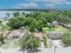 An aerial view of a single-Gathering home surrounded by mature trees, with lake views in the background at 906 25Th Nw St, Winter Haven, FL 33881