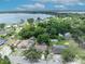 An aerial view of a single-Gathering home surrounded by mature trees, with lake views in the background at 906 25Th Nw St, Winter Haven, FL 33881