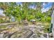 Spacious backyard with an outdoor living area featuring mature trees providing shade at 906 25Th Nw St, Winter Haven, FL 33881
