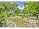 Large backyard with scattered mature trees and plants, partially shaded for recreation and relaxation at 906 25Th Nw St, Winter Haven, FL 33881