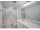 Well-lit bathroom with white cabinets, tiled floors, and shower with patterned curtain at 9199 Waverly Walk Dr, Orlando, FL 32817
