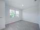 A bright bedroom with light gray wood-look floors, white walls and baseboards, and two windows at 9199 Waverly Walk Dr, Orlando, FL 32817