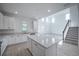 Modern kitchen with granite island, stainless appliances, and stairway adjacent to the open floor plan at 9199 Waverly Walk Dr, Orlando, FL 32817