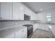Modern kitchen boasts white cabinets, stainless steel appliances, granite countertops and a gas cooktop at 9199 Waverly Walk Dr, Orlando, FL 32817