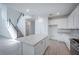 Modern kitchen with granite island, stainless appliances, and stairway adjacent to the open floor plan at 9199 Waverly Walk Dr, Orlando, FL 32817