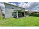 Backyard featuring a covered patio with a dining table, lush green grass and blue skies at 9422 Jaywood Rd, Winter Garden, FL 34787