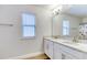 Bathroom featuring double sinks with granite counters, complemented by a well-lit mirror at 9422 Jaywood Rd, Winter Garden, FL 34787