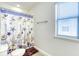 Bright bathroom with a seashell patterned shower curtain and a window with bright light at 9422 Jaywood Rd, Winter Garden, FL 34787