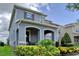 Well-maintained two-story home featuring a covered porch with arched entryways and lush landscaping at 9422 Jaywood Rd, Winter Garden, FL 34787