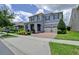 Charming two-story home featuring a brick driveway, three-car garage, manicured landscaping, and a welcoming front porch at 9422 Jaywood Rd, Winter Garden, FL 34787