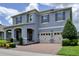Beautiful two-story home with a three-car garage, stone accents, a welcoming front porch, and manicured landscaping at 9422 Jaywood Rd, Winter Garden, FL 34787