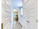 Hallway featuring shaker doors and trim that leads to a kitchen with white cabinets and granite countertops at 9422 Jaywood Rd, Winter Garden, FL 34787