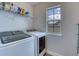 Well-organized laundry room with modern washer and dryer, plus shelving for storage at 9422 Jaywood Rd, Winter Garden, FL 34787