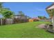 Large backyard featuring a lush lawn, privacy fence, and partially enclosed patio at 9833 Tattersall Ave, Orlando, FL 32817
