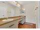 This bathroom features double sinks with a shared vanity, laminate flooring, and neutral tones at 9833 Tattersall Ave, Orlando, FL 32817