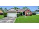 Charming single-story home with a brick facade, well-manicured lawn, and an attached two-car garage at 9833 Tattersall Ave, Orlando, FL 32817