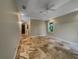 Main bedroom featuring travertine tile flooring, tray ceiling, and natural light from a window at 10170 Se 106Th Ln, Belleview, FL 34420