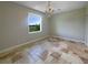 Bedroom featuring travertine tile flooring, a chandelier, and a large window with a scenic view at 10170 Se 106Th Ln, Belleview, FL 34420