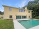 Back exterior featuring a sparkling in-ground pool and a spacious two-story home with large windows at 10170 Se 106Th Ln, Belleview, FL 34420