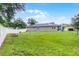 Well-maintained back yard with a white fence, green lawn, and solar panels on the home's roof at 1020 Taproot Dr, Winter Springs, FL 32708